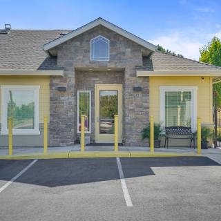 A suburban house with a modern facade and an adjacent parking lot.