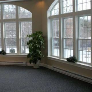 Spacious room with large windows and natural light.