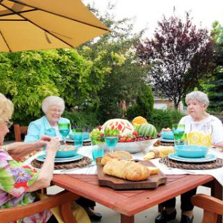 A delightful outdoor gathering with friends enjoying a meal together in a beautiful garden.