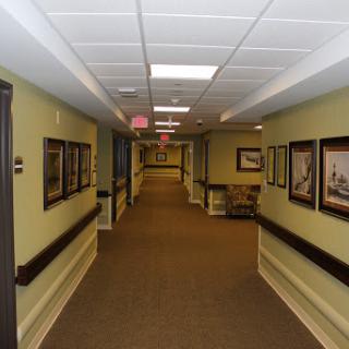 A well-lit and decorated hallway featuring framed artwork along the walls.