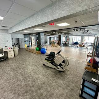 A spacious and modern office area featuring fitness equipment alongside traditional workspace elements.