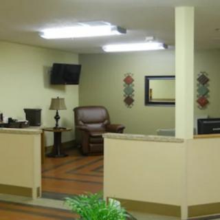 A cozy waiting room with a TV, armchair, and decorative elements.