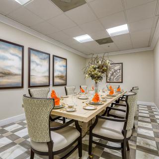 Elegant dining room with a beautifully set table, featuring decorative artwork and comfortable seating.