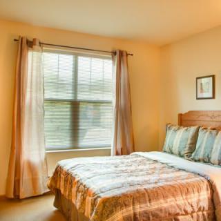 A cozy bedroom with a bed and window letting in natural light.