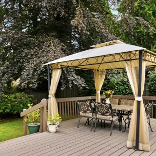 A cozy outdoor gazebo on a wooden deck surrounded by lush greenery.