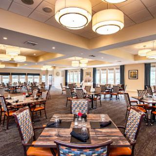A spacious and elegant dining room featuring modern decor and ample seating.