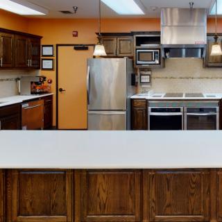 A modern kitchen with stainless steel appliances and wood cabinets.