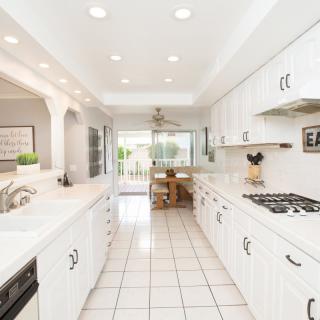 A bright and modern kitchen with white cabinets and tiled flooring.