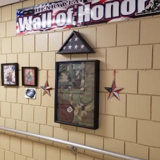 A Wall of Honor displaying military-themed decorations and photographs.
