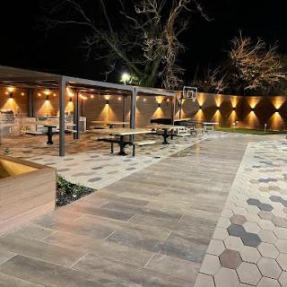 A stylish outdoor dining area with modern decor illuminated at night.