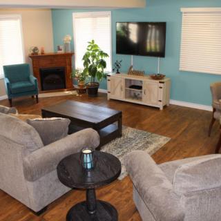 A cozy living room with modern furniture, a fireplace, and a wall-mounted television.