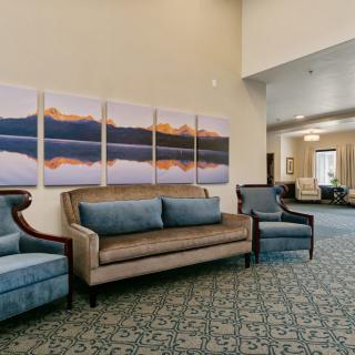 A spacious lobby with elegant seating and scenic artwork on the wall.