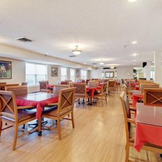 Spacious dining area with tables set with red tablecloths.