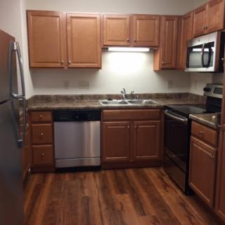 Modern kitchen with wooden cabinets and stainless steel appliances.