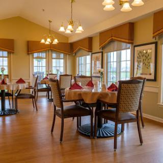 A cozy dining area with well-set tables and warm lighting.