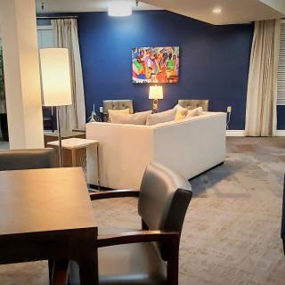 A modern living room with a cozy sofa, vibrant artwork, and elegant lighting.