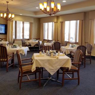 A well-set dining room with neatly arranged tables and elegant lighting.