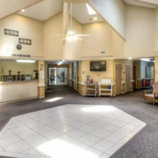 A spacious and well-lit lobby area with a reception desk and seating.