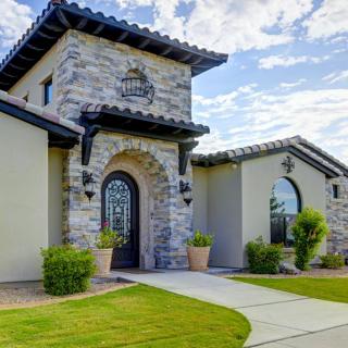 A modern house with a stone facade and well-maintained landscaping.