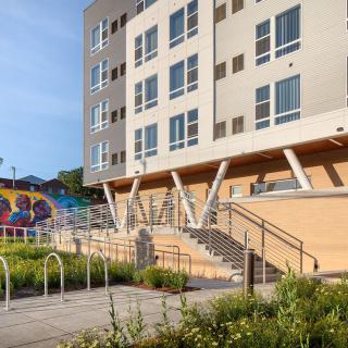 A modern apartment building with a colorful mural on its exterior wall.