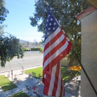 An American flag waving outside a building on a sunny day.