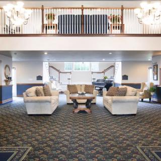 A spacious and elegantly designed lobby area with sofas and chandeliers.