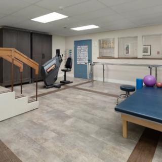 A physical therapy room equipped with exercise equipment and therapy tools.