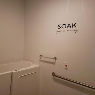 An accessible bathroom featuring a walk-in bathtub with handrails.