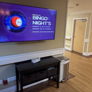 A promotional display for Bingo Nights in a community space, featuring a television screen and a welcoming interior.