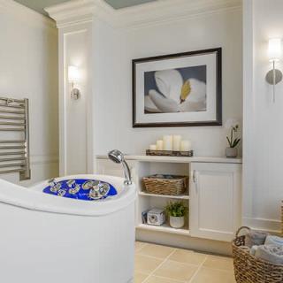 A modern bathroom featuring a luxurious bathtub, elegant decor, and soothing lighting.