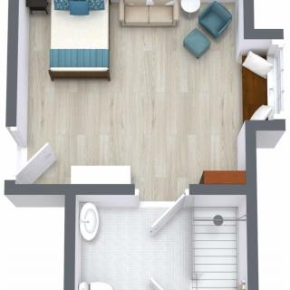 A 3D floor plan showing a small apartment layout with a bedroom, seating area, and bathroom.