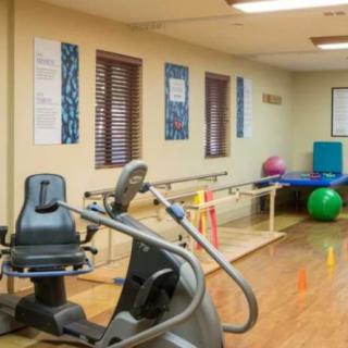 A rehabilitation room with exercise equipment and therapy tools.