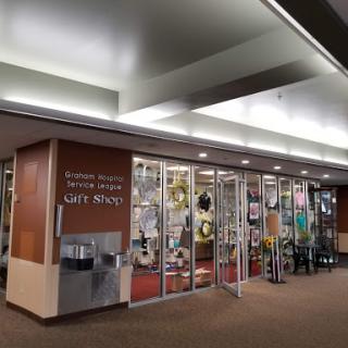 A welcoming entrance to a cafe, featuring a display of various items in the window.