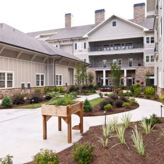 A well-maintained residential building with landscaped gardens and a winding pathway.