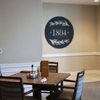 A cozy dining area with a table and chairs, featuring wall decor displaying '1804'.