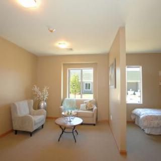 A cozy open-plan living room and bedroom with neutral decor.