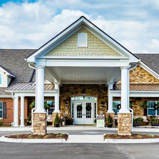 A building with a welcoming entrance featuring columns and brick and stone design.