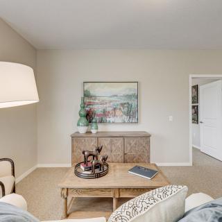 A cozy living room with neutral tones, featuring a large lamp, artwork on the wall, and a stylish coffee table.