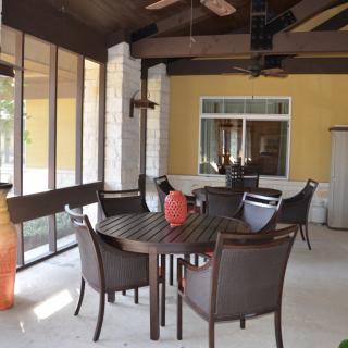 An inviting outdoor patio space featuring a dining table and chairs, surrounded by a screened enclosure.