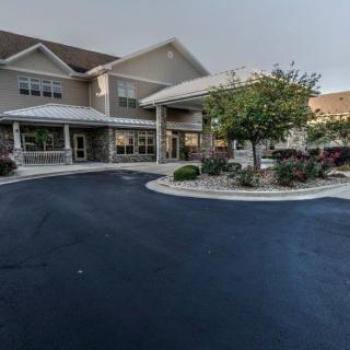 A residential building with a well-maintained driveway and landscaped entrance