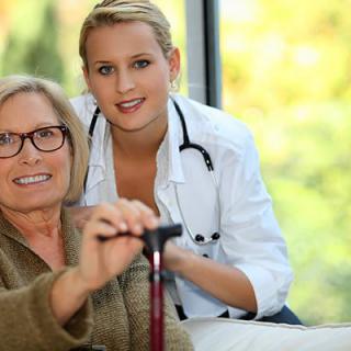 A medical professional assisting a senior woman at home.