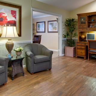 A cozy living room with armchairs and a wooden desk.