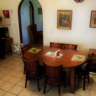 A cozy dining area featuring a wooden table and chairs, complemented by artwork on the walls.