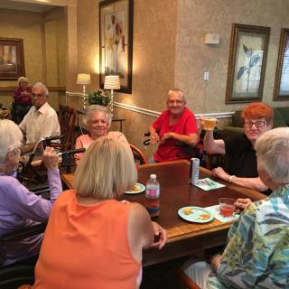 A group of seniors enjoying a meal and conversation together indoors.