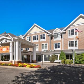 A three-story hotel building with a welcoming entrance and well-maintained landscaping.