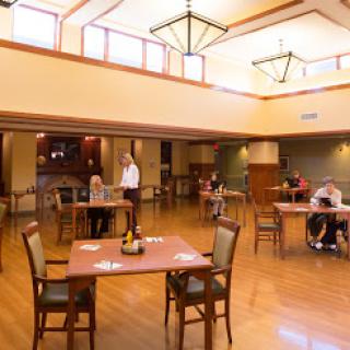 A spacious dining area with wooden flooring and ample natural light.