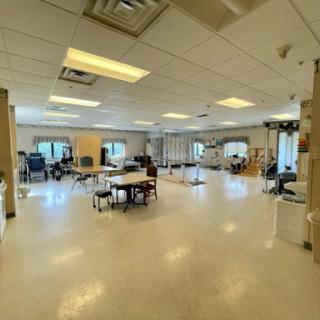 A spacious and well-lit office or workspace featuring various tables and chairs.