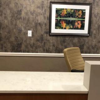 An empty office reception desk with a painting on the wall.