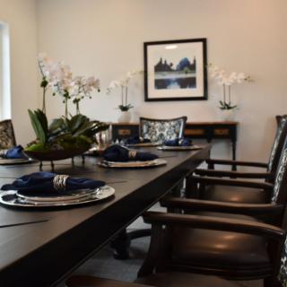 A stylish dining room with elegant table settings and decorative orchids.
