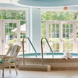 A serene indoor spa area featuring a jacuzzi surrounded by natural light.